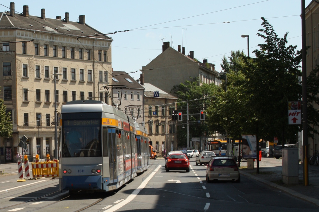 Straßenmündung mit PKW und Tram.
