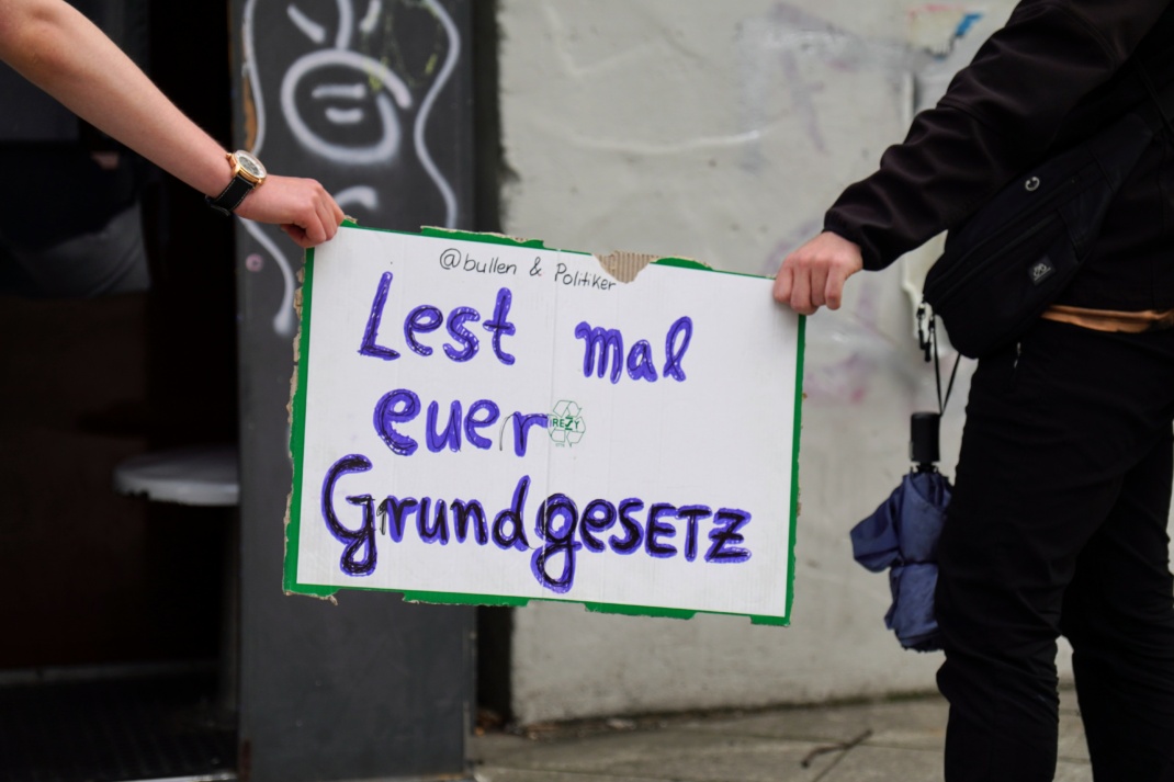 Schild mit der Aufschrift "Lest mal euer Grundgesetz"