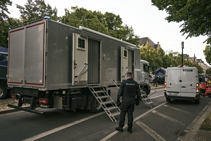 Toilettenwagen der Polizei mit Fahrer davor.