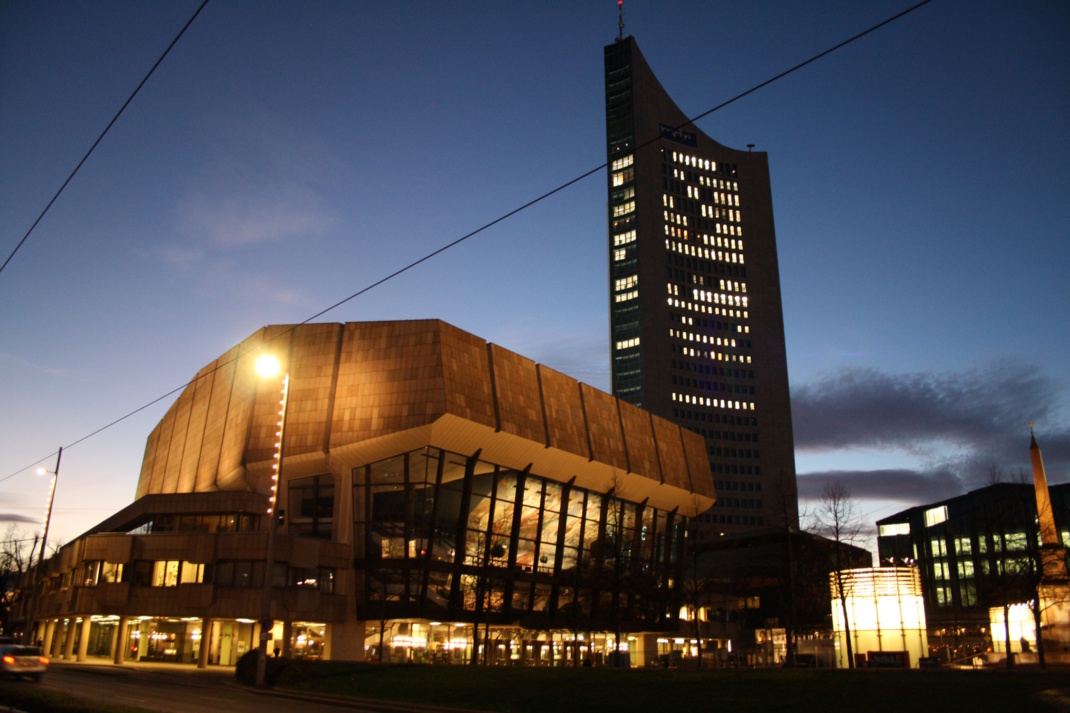 Beleuchtetes Gewandhaus in der Dämmerung mit Uniriese.