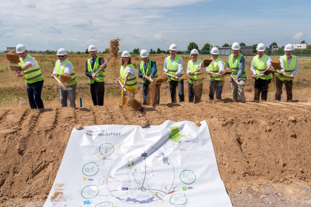 Gruppe beim Spatenstich in einer Reihe.
