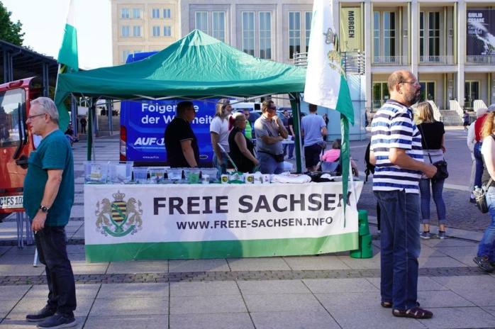 Grünes Zelt mit der Aufschrift "Freie Sachsen", darunter mehrere Personen