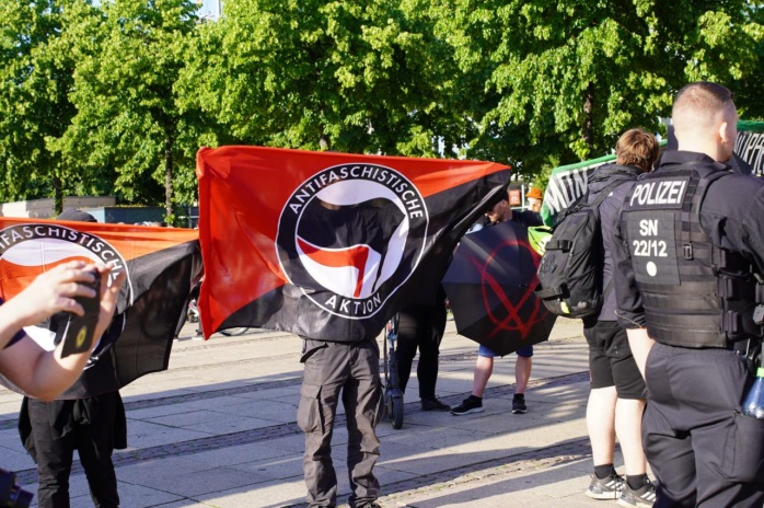 Personen mit Fahnen der Antifa in schwarz-rot-weiß