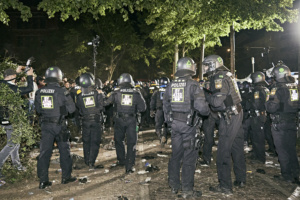 Eine Reihe Polizist*innen hat eine große Gruppe Menschen eingeschlossen.