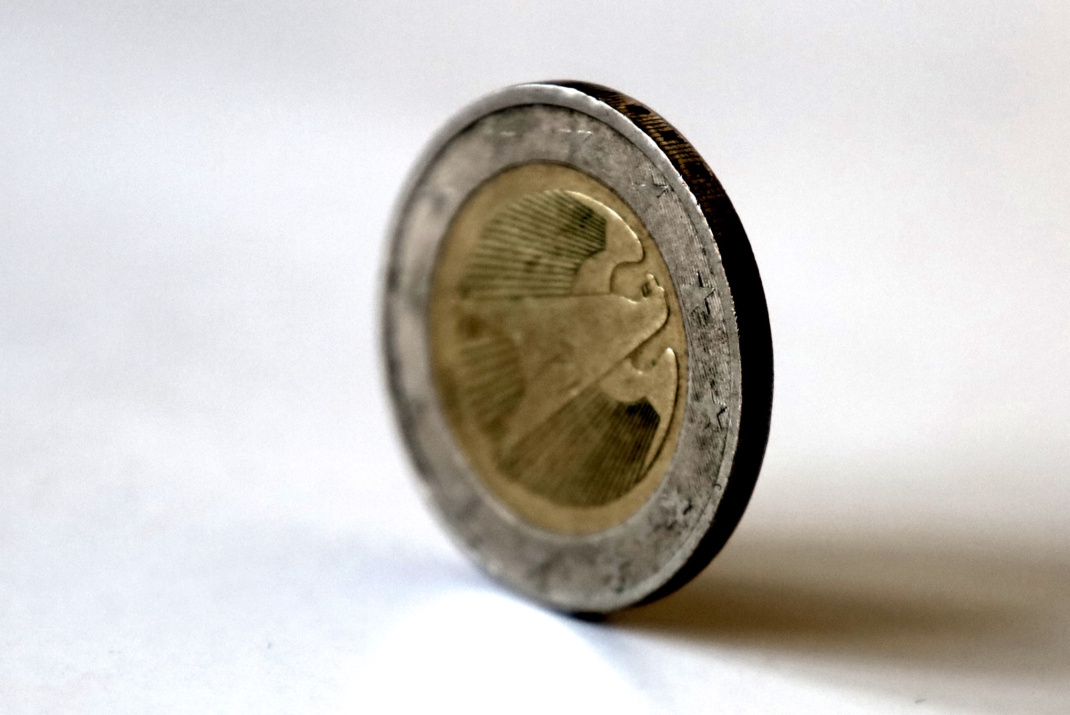 Zwei-Euro-Stück steht auf dem Rand.