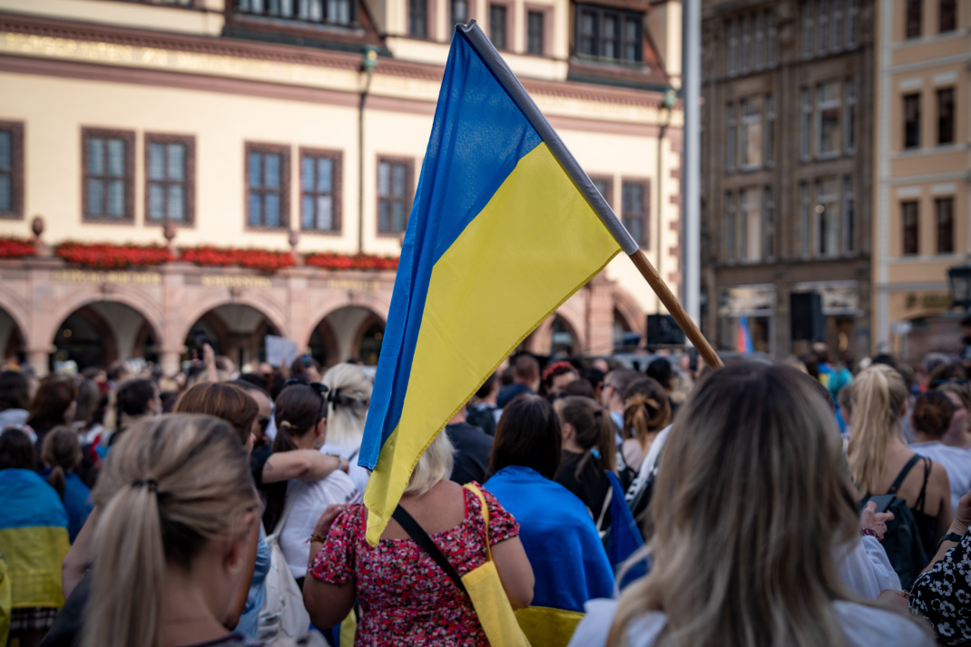 Ukraine-Demo mit Flagge des Landes inmitten einer Menschenmenge.