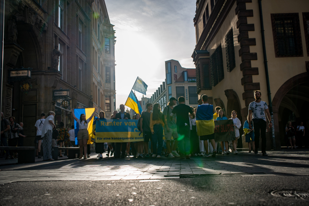Menschen mit ukrainischen Flaggen marschieren bei einer Demonstration.