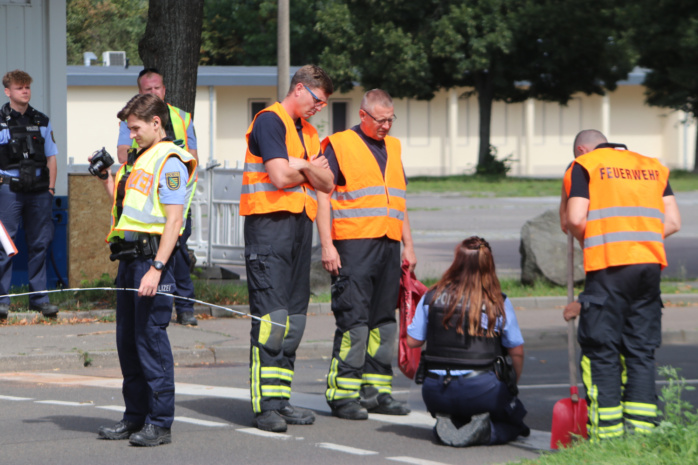 Feuerwehrleute und Polizisten bei Begutachtung der Straße.