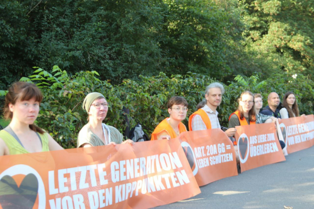 Aktivisten der Letzten Generation auf dem Gehweg,