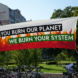Banner mit der Aufschrift "You burn our planet, we burn your system"