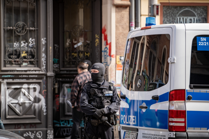 Bewaffneter und maskierter Polizist bei Hausdurchsuchung.