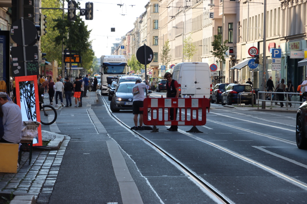 Straßenszene, BAustellenabsperrung und Autos.