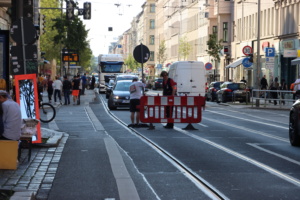 Straßenszene, BAustellenabsperrung und Autos.