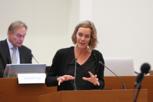 Juliane Nagel am Rednerpult im Stadtrat, Burkhard Jung im Hintergrund.