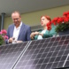 Zwei Menschen auf dem Balkon, im Vordergrund eine Solaranlage.