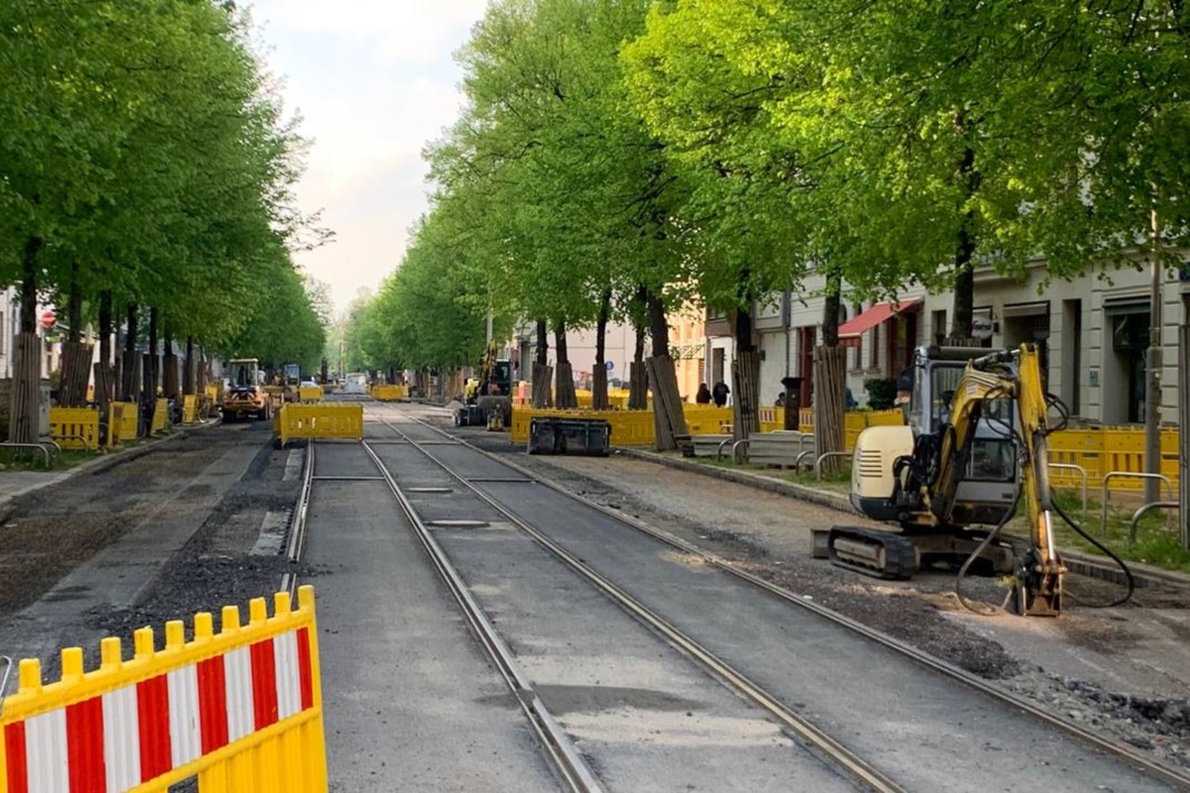 Baustelle, Baufahrzeuge und Absperrungen auf der Straße.