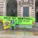 Protest vor dem Neuen Rathaus zum Internationalen Tag gegen Holzverbrennung in Kraftwerken, Menschen mit Bannern am Eingang.