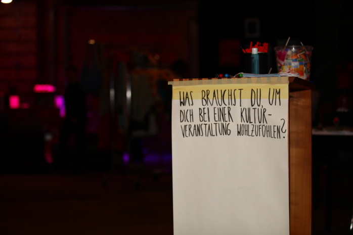 Schild mit der Aufschrift "Was brauchst du, um dich bei einer Kulturveranstaltung wohlzufühlen?"