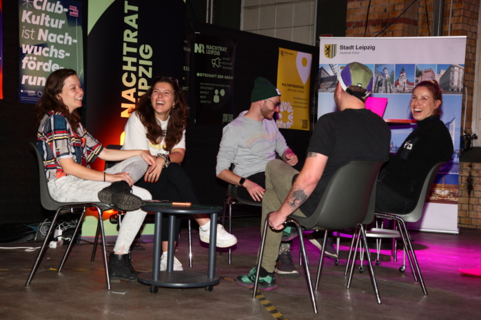 Mehrere Personen in einem Stuhlkreis unterhalten sich und lachen