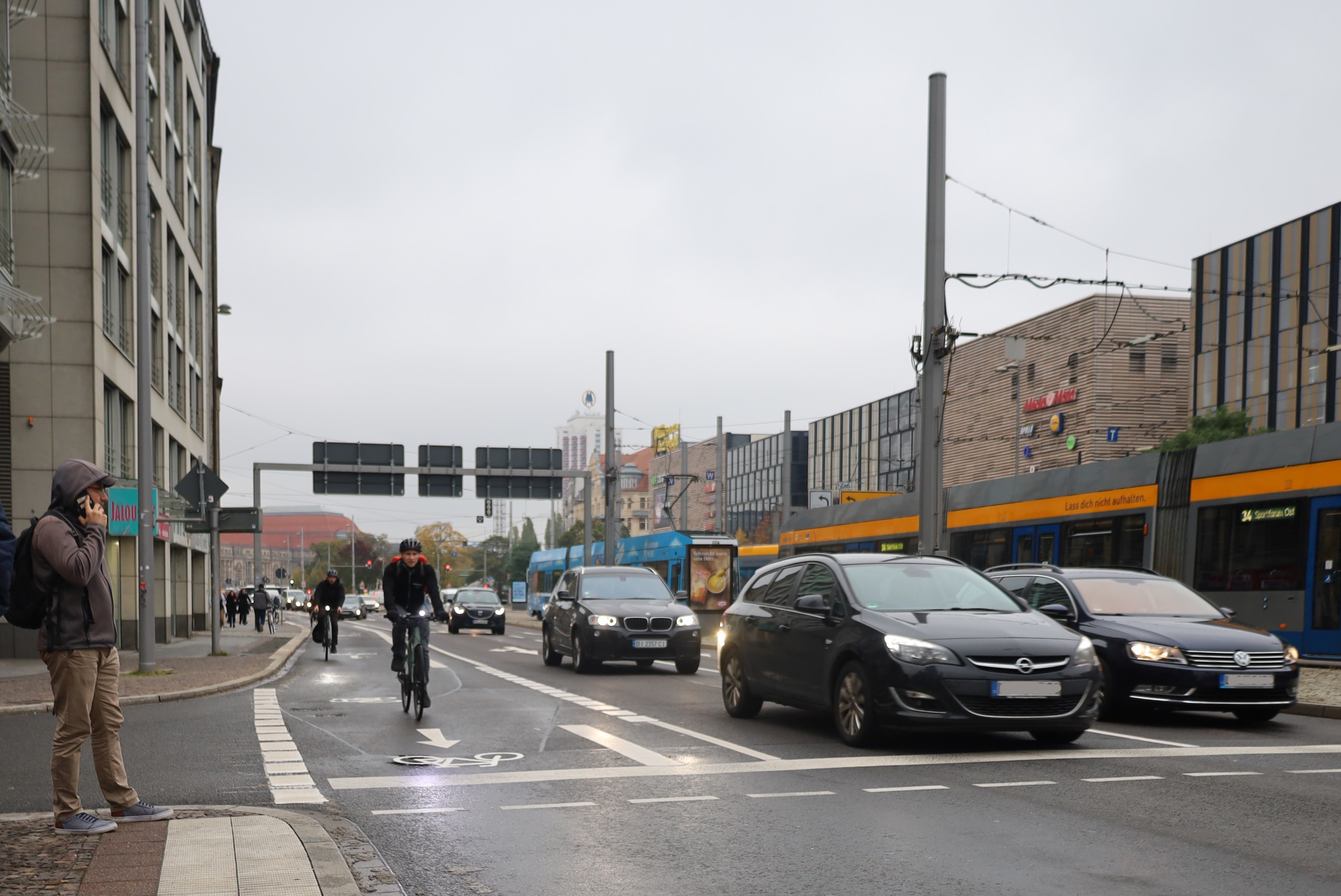 Befahrene Straße mit Autos, Radfahrer und Tram in Leipzig.