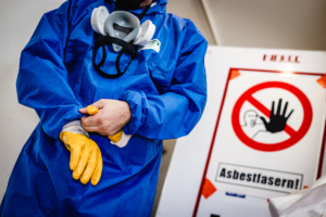 So läuft Asbest-Sanierung: Overall, Atemschutzmaske, Handschuhe und dazu noch eine Schutzbrille. „Komplett- Schutz ist ein Muss“, sagt die Bau-Gewerkschaft.