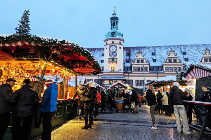 Marktplatz mit Menschen, Buden, im Hintergrund Rathausturm