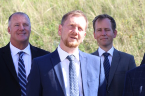 Drei Männer mit Anzügen und Krawatte.