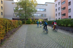 Gebäude der Stadtteilbibliothek, Personen zum Teil auf Fahrrad.