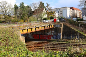 Brücke, die über Bahngleise führt, Seitenaufnahme.