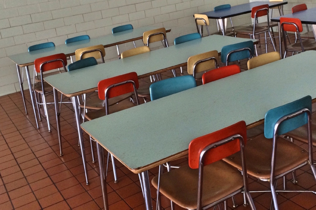 Cafeteria, Esstische und bunte Stühle.