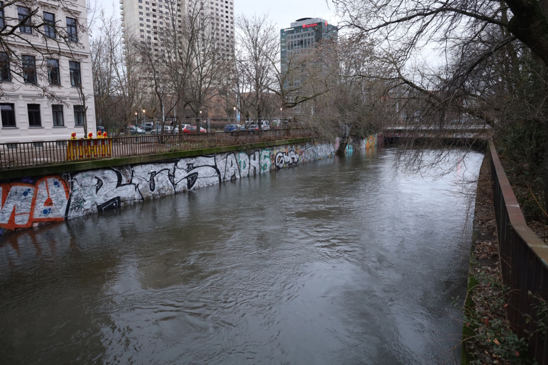 Fluss, umgeben von Gebäuden und Bäumen.