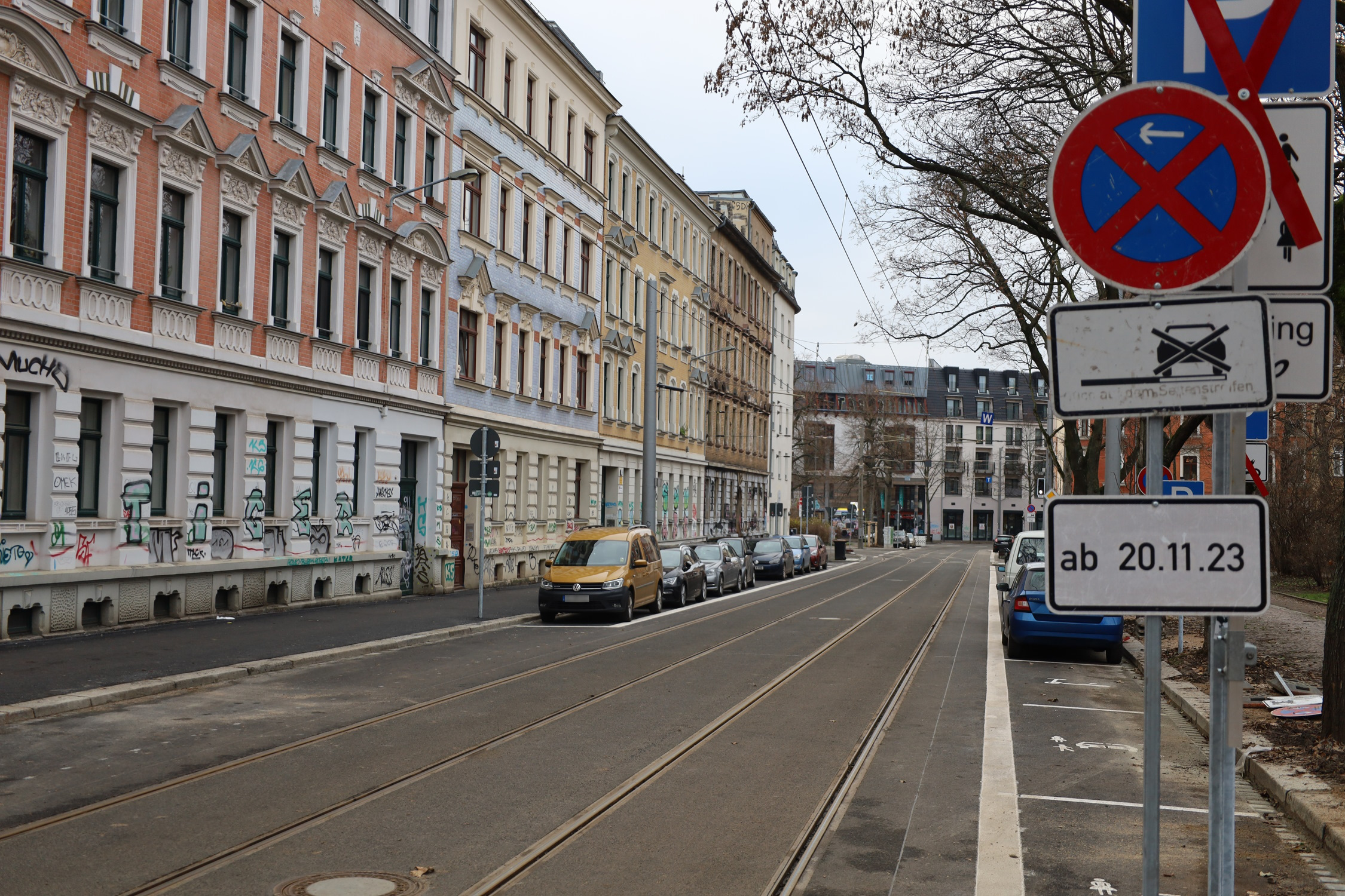 Straße, Hausfassaden und parkende Autos.