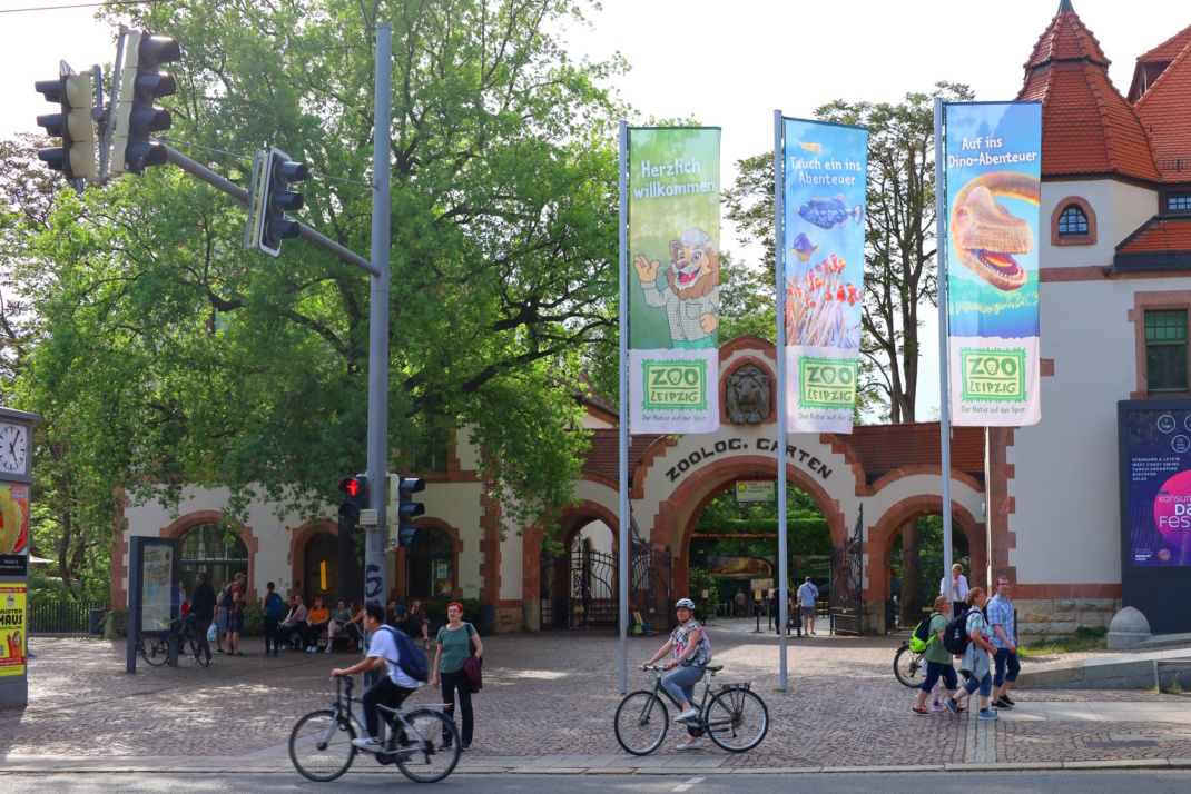 Straße, Mäste mit Fahnen, Fahrräder und Personen.