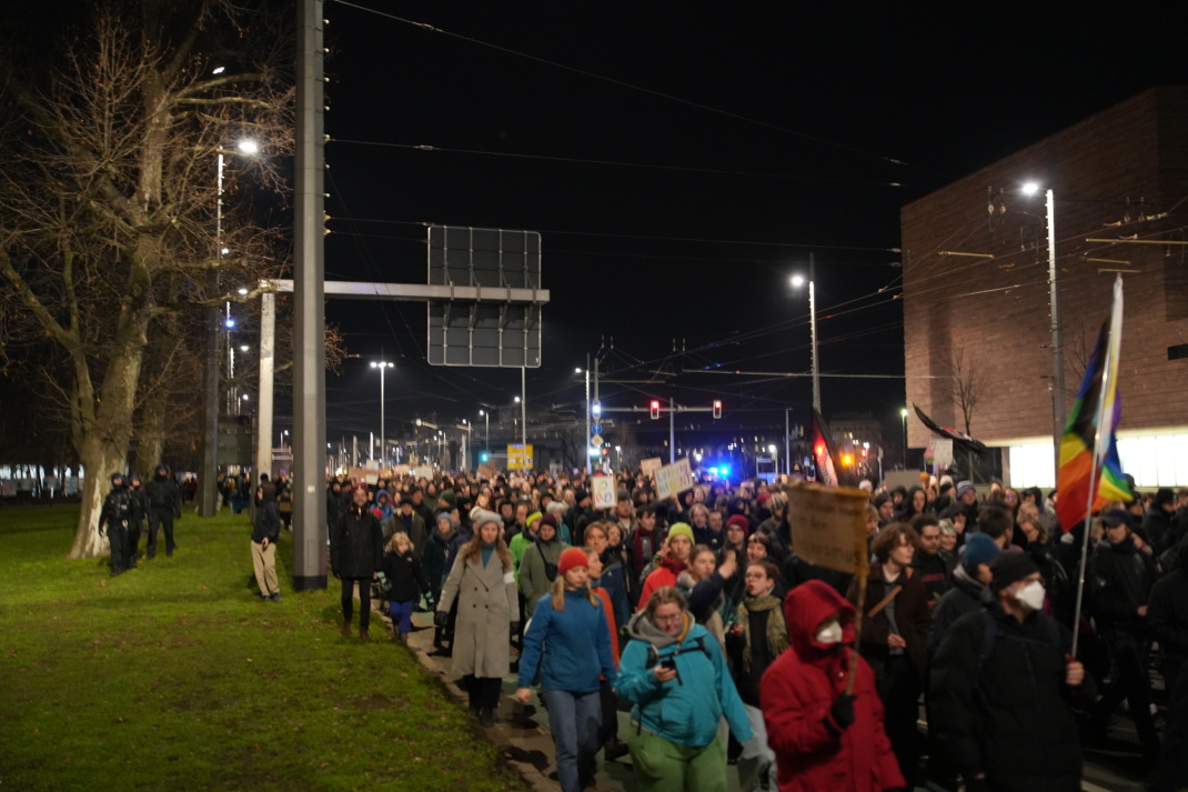 Menschenzug marschiert auf einer Straße.
