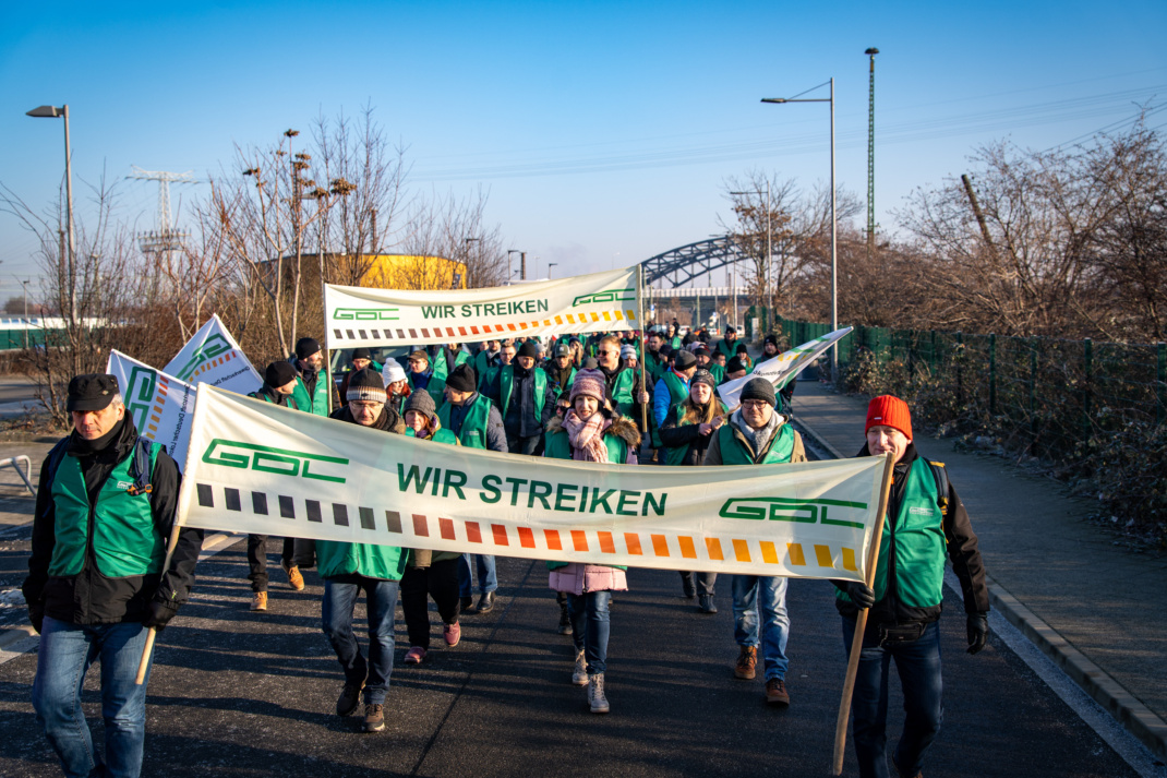 Streikende Personen mit Banner.
