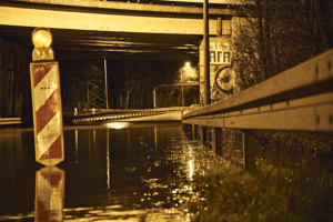 Überschwemmung unter einer Brücke, Warnbake.