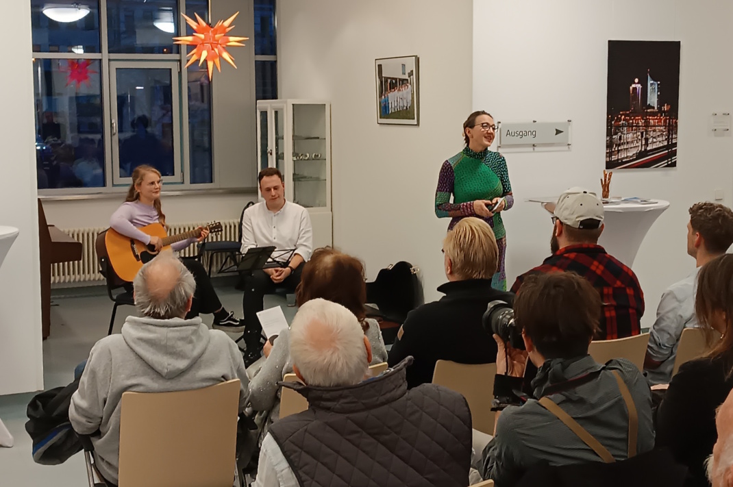 Menschen in einem Raum, sitzend und stehend.