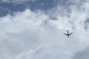 Flugzeug am Himmel und Wolken, von unten aufgenommen.