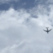 Flugzeug am Himmel und Wolken, von unten aufgenommen.