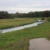 Fließgewässer mit Uferbereich, grüne Wiese.