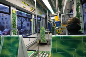 Innenraum einer Tram mit grünen Sitzen.