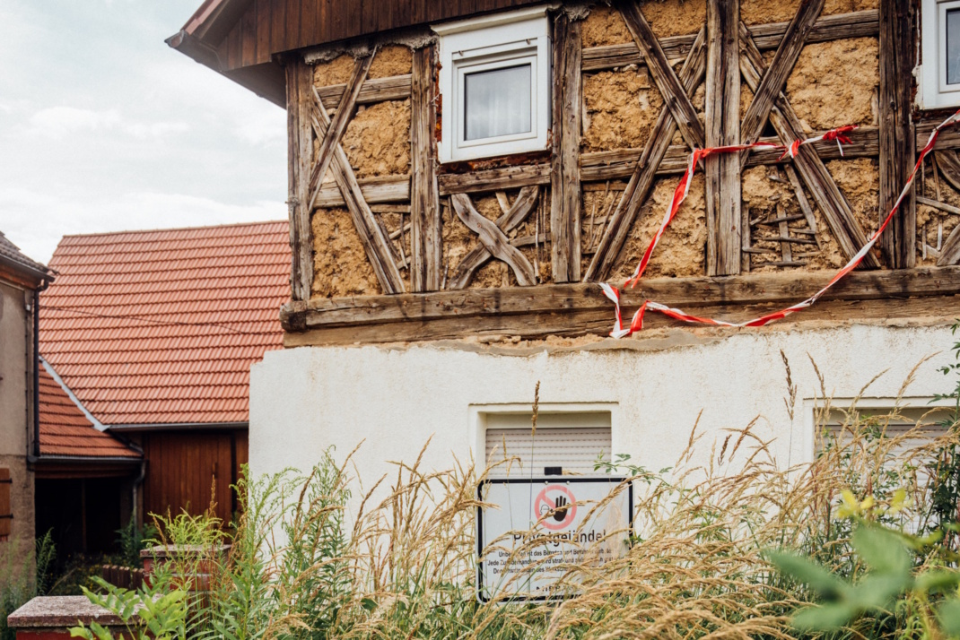Fachwerkhaus, Gehöft mit Pflanzenbewuchs.