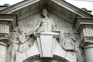 Figurenrelief und Giebel an einem Eingangsportal.