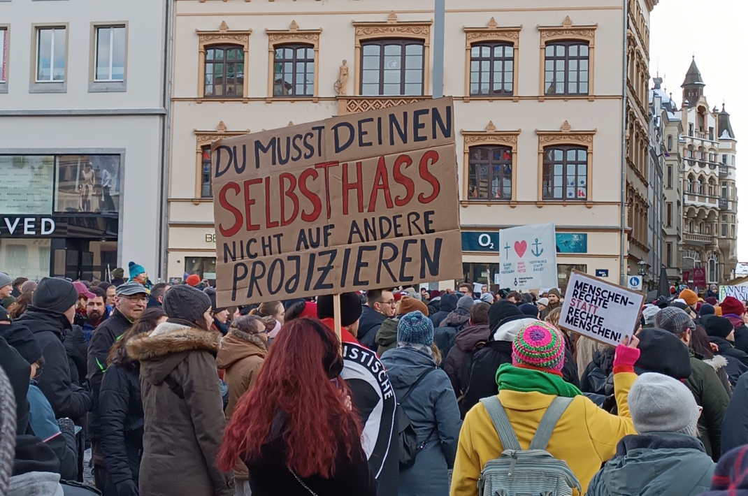 Protestierende Menschen mit Plakaten.