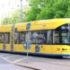 Gelb lackierte Straßenbahn unterwegs.