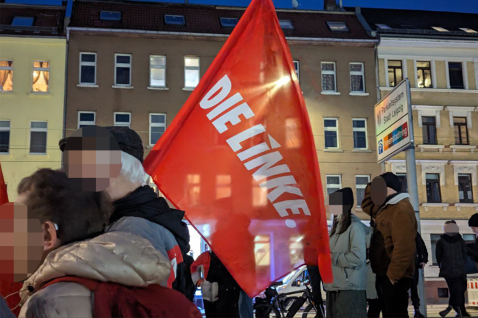 Pärchen im Vordergrund, in der Mitte eine rote Fahne zu sehen