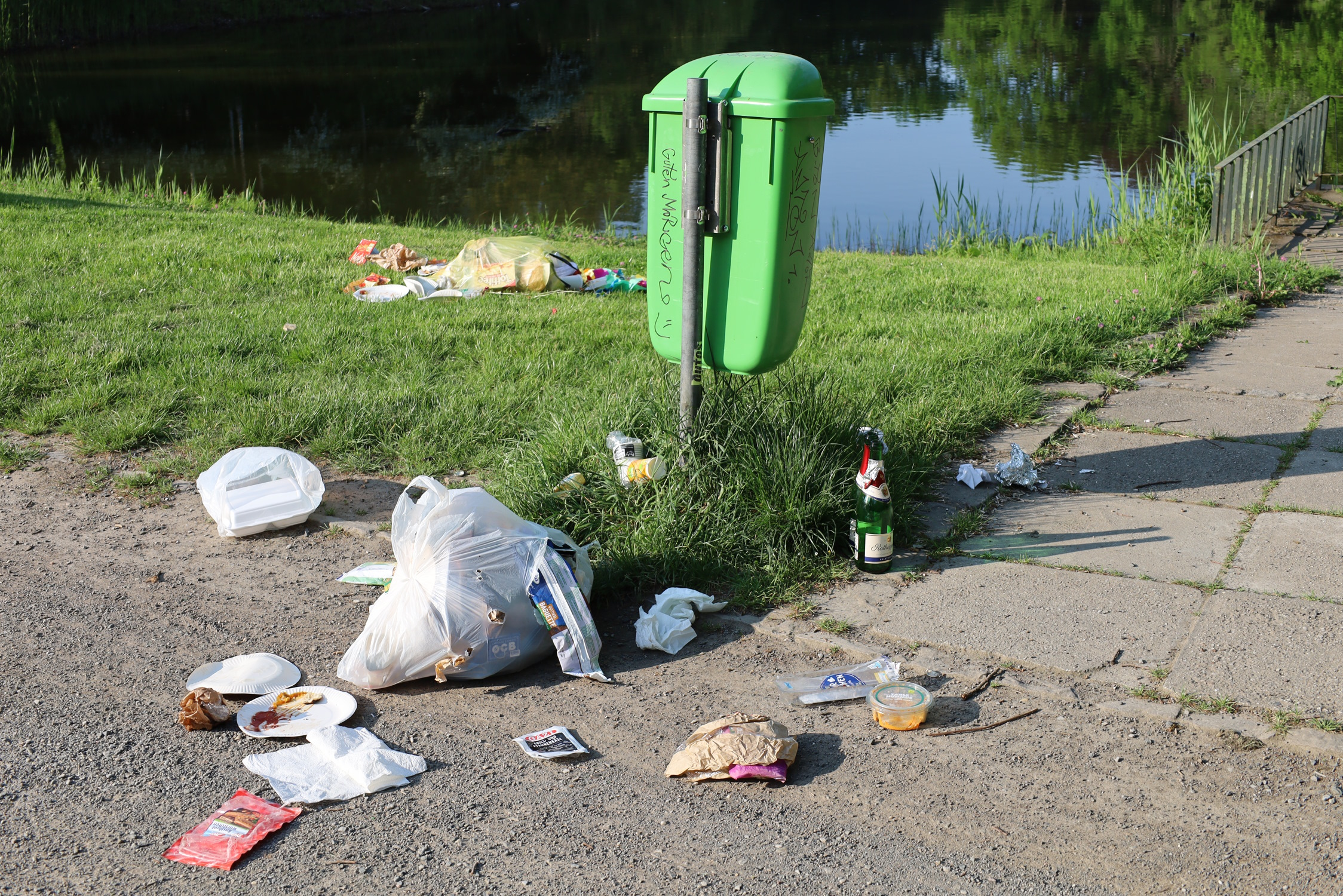 Öffentlicher Müllbehälter, Abfall liegt daneben.