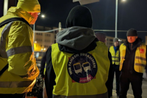 Streikende Personen in der Dunkelheit mit farblicher Bekleidung.