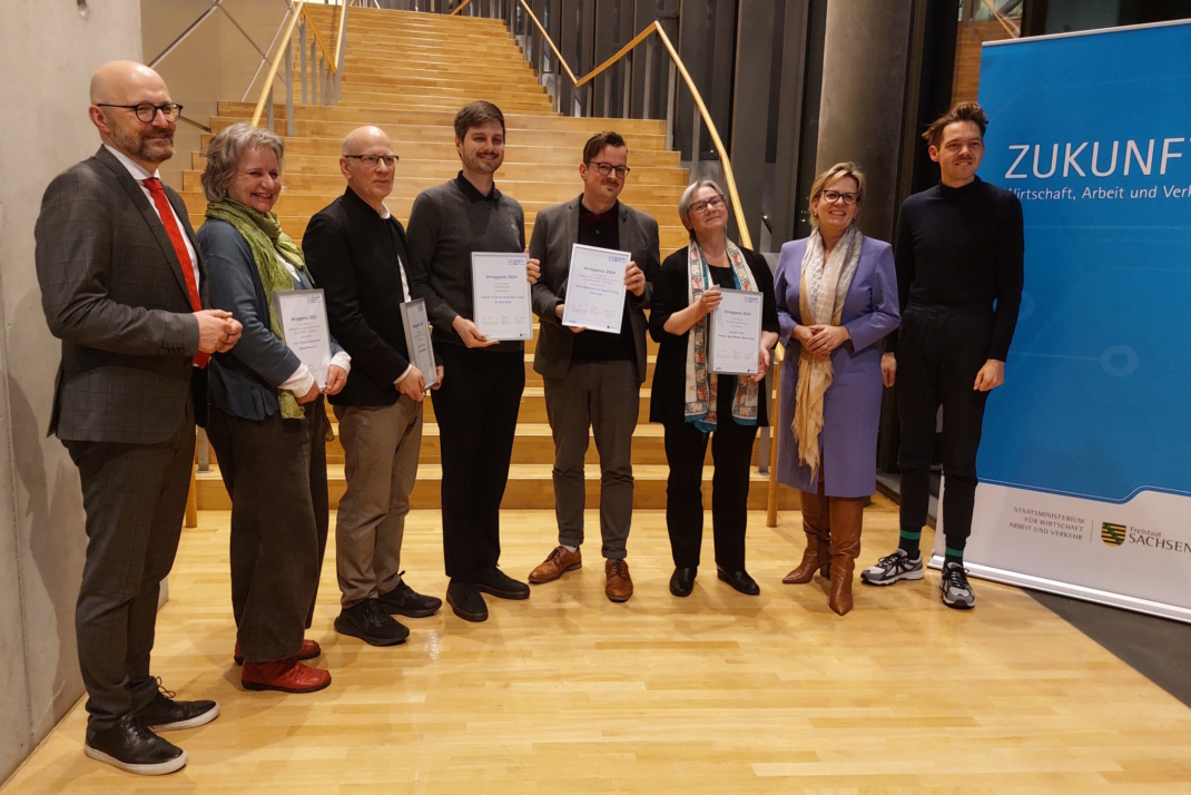 Personengruppe in Reihe, Auszeichnungen haltend.