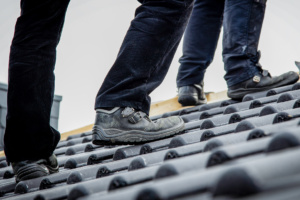 Oben auf dem Dach wartet jede Menge Arbeit – und für die gibt es ein „Mindest-Lohn- Preisschild“: 15,60 Euro pro Stunde – das ist das Minimum, was Gesellen auf dem Dach verdienen müssen. Foto: IG BAU | Tobias Seifert